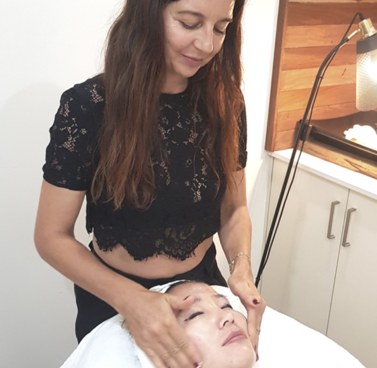 Jade Wieland, founder of Skin Body Health, performing a facial treatment